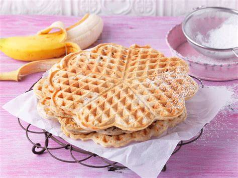 Familie beim Backen und Genießen von Bananenwaffeln