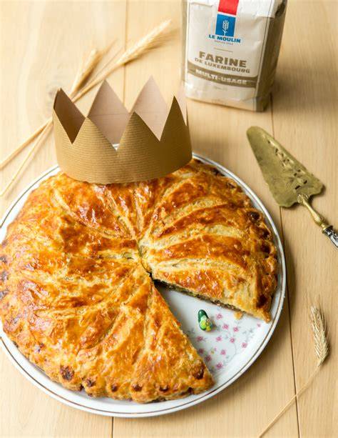Familie beim Teilen einer Galette des Rois mit Papierkrone