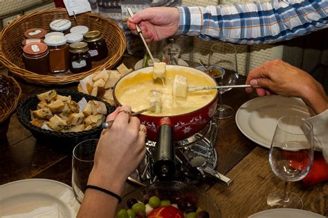 Familie und Freunde genießen Käsefondue am Festtagstisch