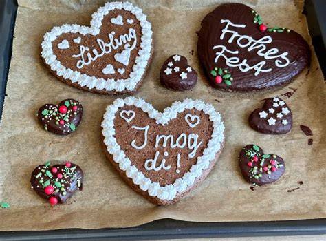 Familienbacken: Kinder verzieren Lebkuchenherzen am Tisch