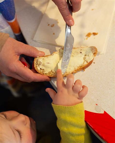 Familienmoment: Kinder bestreichen Brot mit geschmolzener Schokolade