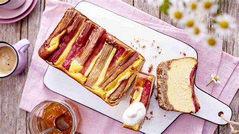 Familientafel im Frühjahr mit Rhabarber-Käsekuchen, Kaffeetassen und Rhabarberstangen