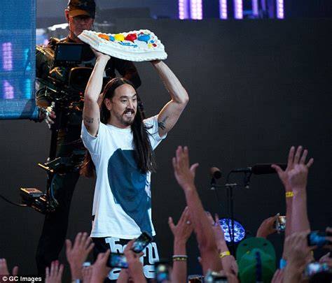 Fans mit „Cake Me“-Schildern beim Steve Aoki Konzert