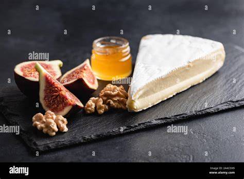 Feigenmarmelade auf Käseplatte neben Ziegenkäse und Camembert