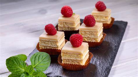 Fein dekorierte Petit Fours mit Schokoladenglasur und farbiger Verzierung