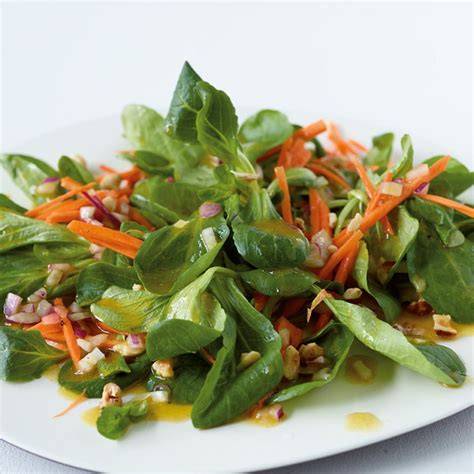 Feldsalat auf Teller mit Honig-Dressing