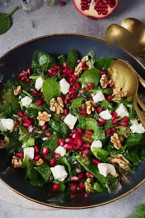 Feldsalat mit Granatapfel, Walnüssen und Dressing angerichtet