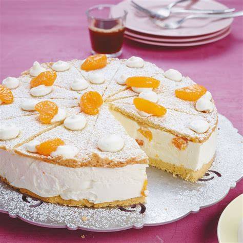 Fertig dekorierte Quarktorte mit frischen Früchten und Sahnetuffs