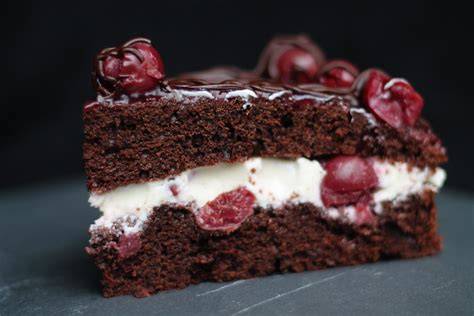 Fertig dekorierte Schoko-Kirsch-Torte mit Schokoguss und Kirschen