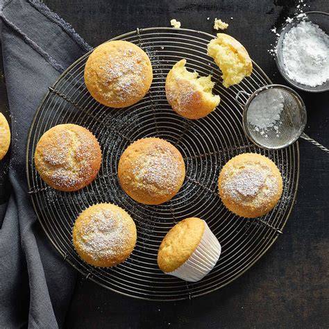 Fertig gebackene Muffins auf einem Kuchengitter, bestäubt mit Puderzucker