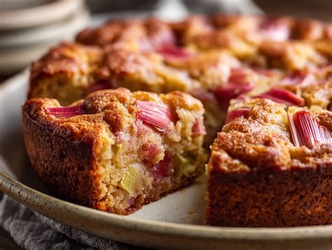 Fertig gebackener, goldbrauner Rhabarberkuchen auf dem Backblech, Puderzucker darüber gestreut
