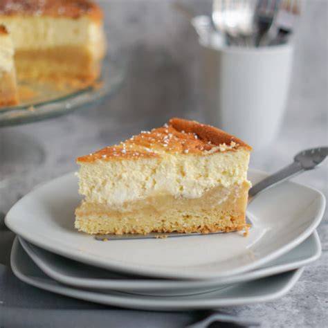 Fertig gebackener Käsekuchen mit Apfelmus und Puderzucker