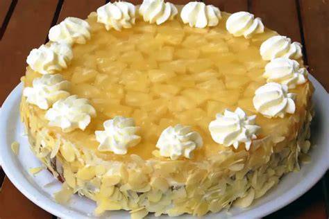 Fertig verzierte Ananastorte mit Sahnetuffs und Ananasstückchen