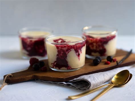 Fertige Gläser mit Pudding und Beerensauce, schichtweise angerichtet und bunt dekoriert