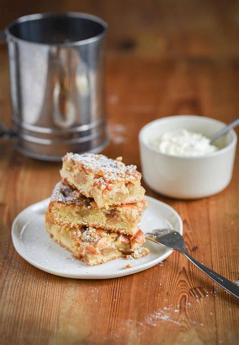 Fertige Mini-Marzipanstollen auf einem Servierteller, bestäubt mit Puderzucker