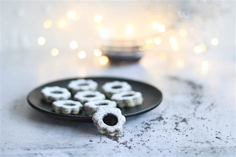 Fertige Mohn Marzipan Plätzchen mit Puderzucker auf einem weihnachtlichen Teller