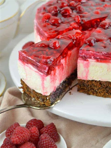 Fertige Mohn-Topfen-Torte mit Himbeerspiegel und frischen Himbeeren dekoriert