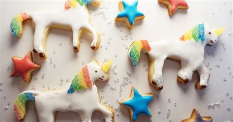 Fertige bunte Einhorn Kekse, Kinder und Familie beim Dekorieren und Staunen