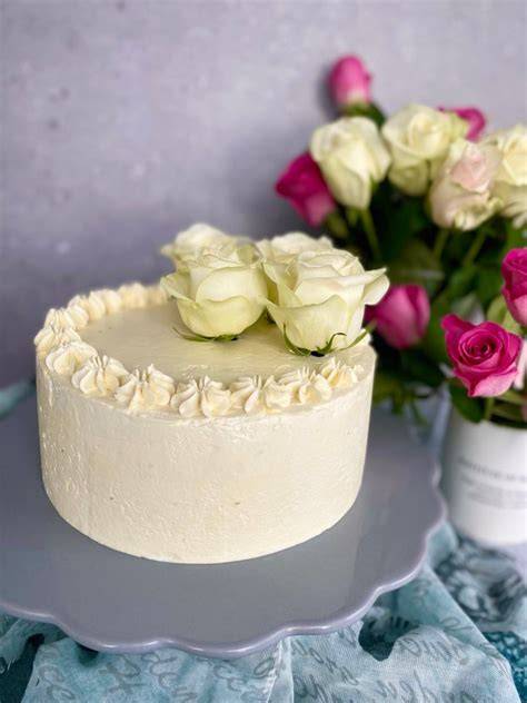 Fertige weiße Torte mit glatter Buttercreme-Oberfläche und Dekoration