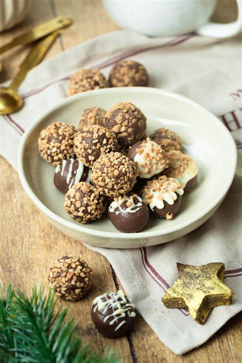 Festliche Deko: Goldstaub, Pralinen, Orangenzesten und Schokoladenspäne auf einer Lindt-Torte