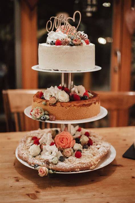Festliche Hochzeitstorte auf einer Etagere mit Blumen und Beeren