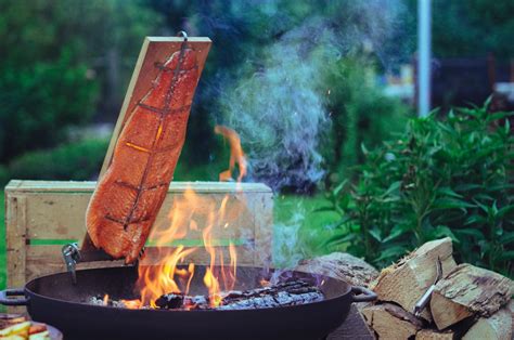 Flammlachs am offenen Feuer auf einem Holzbrett