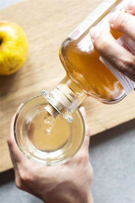 Flasche Apfelessig mit Honig auf Küchentisch