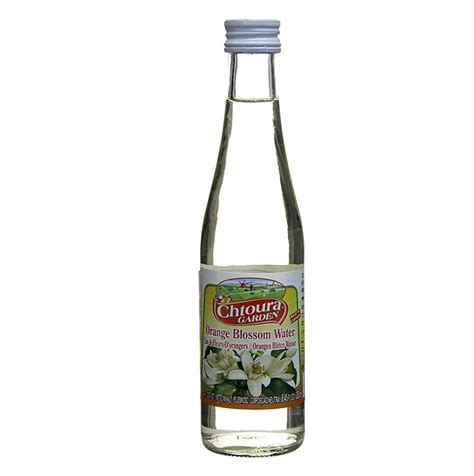 Flasche Orangenblütenwasser neben Zitronen und Mandeln