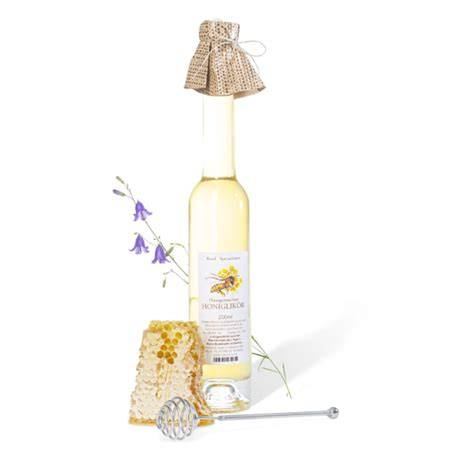 Flasche mit Honiglikör und Honigwabe