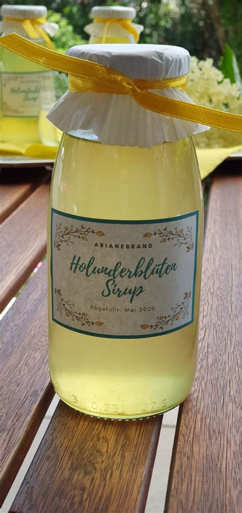 Flaschen mit Holunderblütensirup und Etiketten „Sirupzucker verwendet“