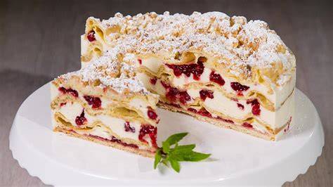 Flockensahnetorte angeschnitten - Querschnitt mit Brandteig, Kompott und Sahne