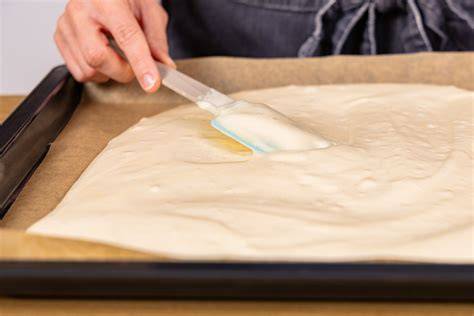 Fluffiger Biskuitteig wird auf Backblech verteilt
