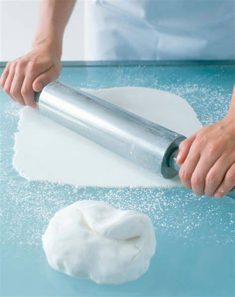 Fondant ausrollen auf Arbeitsfläche mit Puderzucker
