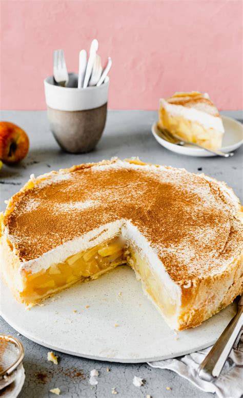 Foto: Apfel‑Schmand‑Kuchen auf weißem Teller, mit Zimt bestäubt