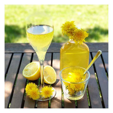 Foto: Glas mit Löwenzahnsirup neben Wildblumen