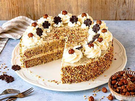 Foto einer Nuss Sahne Torte auf Tortenplatte, mit Nuss-Pralinen dekoriert