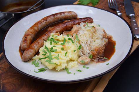 Foto einer fertig geschichteten Schnitzeltorte mit Kartoffelpüree und Möhrenmus