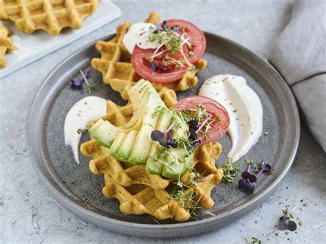 Foto von frisch gebackenen Linsenwaffeln auf Teller mit Kräuter-Dip