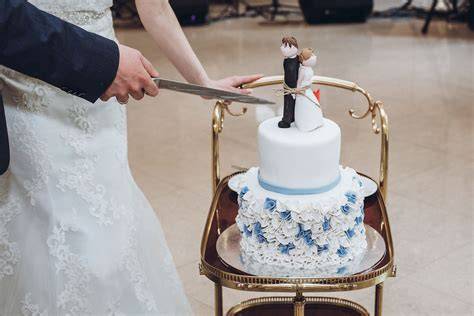 Fotomoment Brautpaar schneidet Hochzeitstorte mit individueller Figur