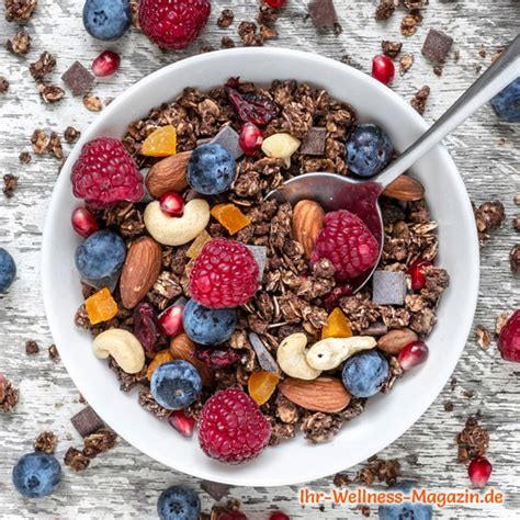 Frühstücksbowl aus Schoko Granola mit Beeren und Milch serviert