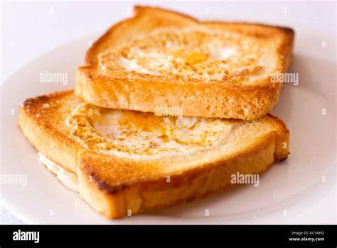 Frühstücksszene: getoastetes Brot mit Bananen-Johannisbeer-Marmelade, Kaffee und Butter