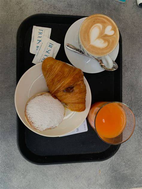 Frühstückstablett mit Croissant, Kaffee und Saft