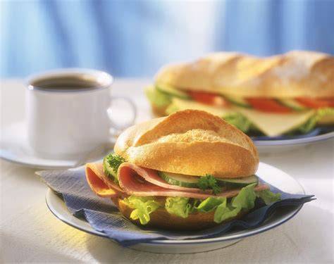Frühstückstablett mit belegten Brötchen und Kaffee
