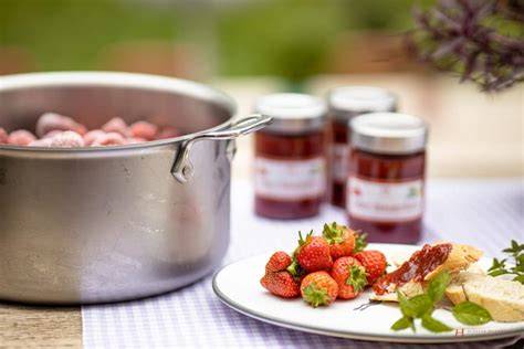 Frühstückstisch mit verschiedenen Marmeladen und frischen Erdbeeren