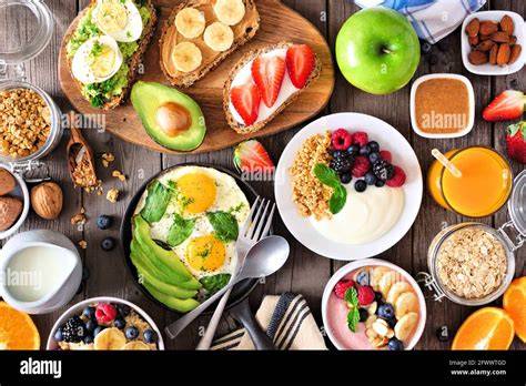 Frühstückstisch mit verschiedenen Marmeladensorten, Toast, Vollkornbrot und frischem Obst