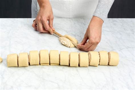 Franzbrötchen vor dem Formen mit Kochlöffelstiel eingedrückt