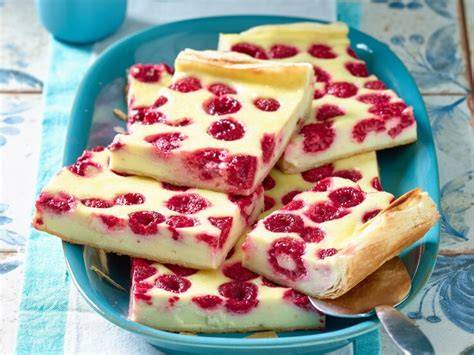Frisch angeschnittener Himbeer-Pudding-Blechkuchen auf Teller