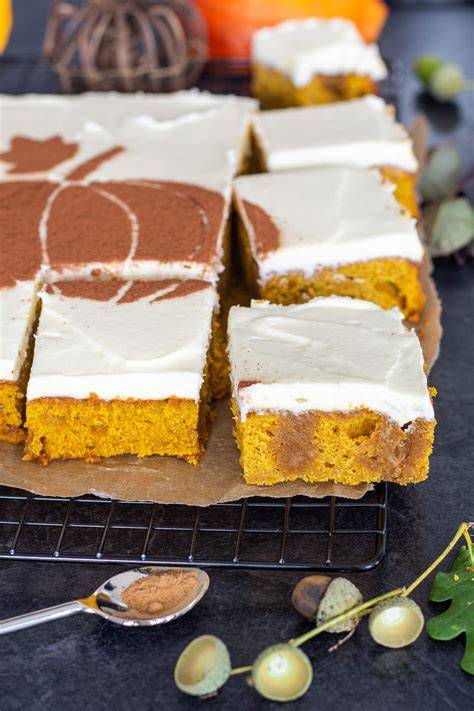 Frisch angeschnittener Kürbiskuchen mit Topping und Herbstdeko