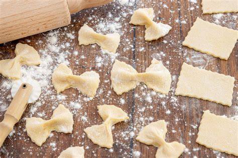 Frisch ausgerollter Nudelteig mit ausgestochenen Quadraten für Tortelli