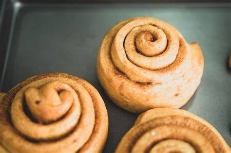 Frisch gebackene Blätterteig-Zimtschnecken auf einem Backblech